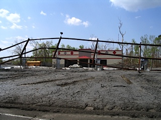 damaged railing with background of mud and empty building