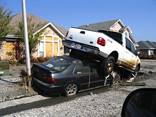 two cars stacked on top of each other on side of the road