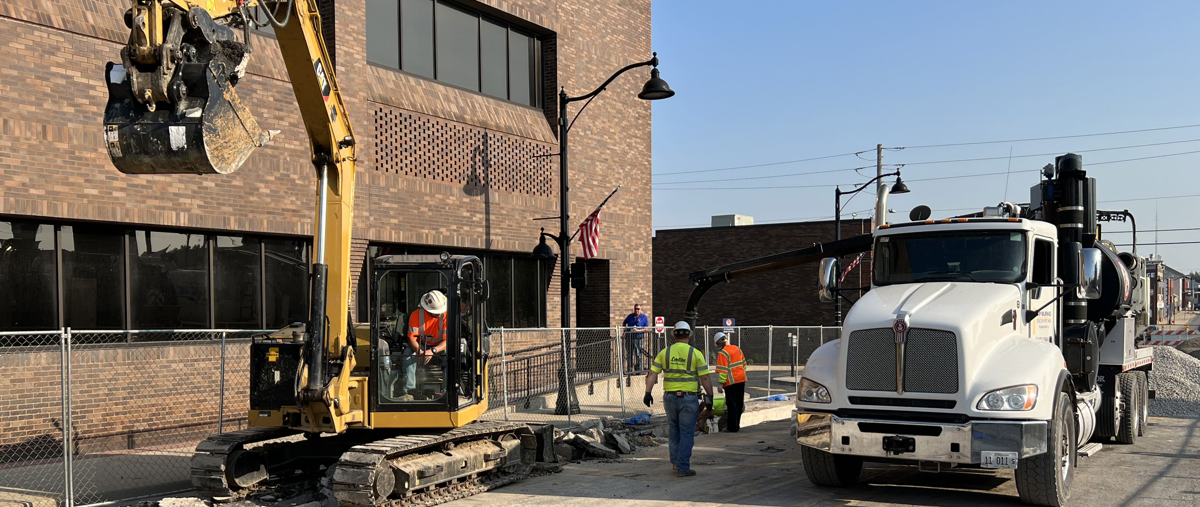 A construction site with a truck and several workers.